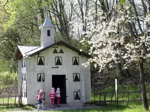 © Bezirk Oberbayern, Archiv BHM Amerang, G. Nixdorf. Kinder laufen zum Bienenhaus im Bauernhaus Museum Amerang.