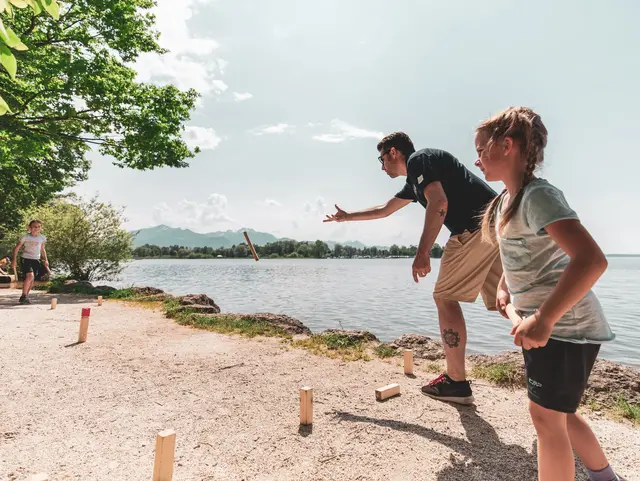 - © Chiemgau Tourismus e.V. Familie spielt Wikingerschach am Chiemsee in Übersee im Sommer