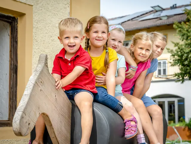- © Medienservice ProGenuss® Kinder sitzen auf einen Spiel-Holz-Pferd.