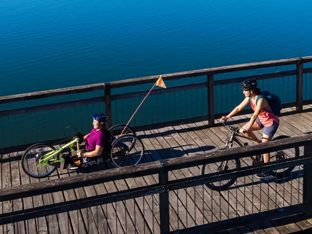 - © Chiemgau Tourismus e.V. Handbikerin und Fahrradfahrerin am Waginger See